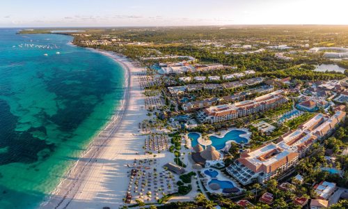 Aerial drone view of beach resort hotels with pools, umbrellas and blue water of Atlantic Ocean, Bavaro, Punta Cana, Dominican Republic