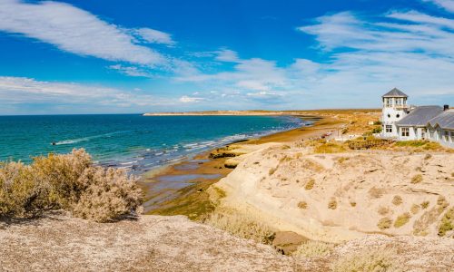 Panoramic over beautiful and colorful at sunset Atlantic coastline near peninsula Valdes, Puerto Madryn city with sandstone cliffs at low tide with alga, seashells and caves, Patagonia, Argentina