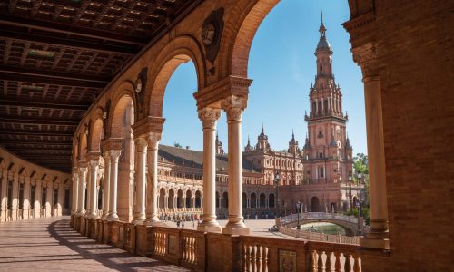 The Plaza de España galleries lited up with evening sunlight making magic shadows. North tower view on Spain Square, Andalusia, South Spain.